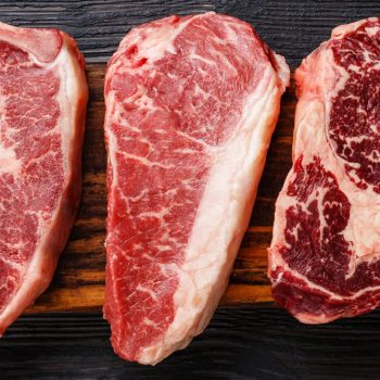 Variety of Raw Black Angus Prime meat steaks Machete, Blade on bone, Striploin, Rib eye, Tenderloin fillet mignon on wooden board